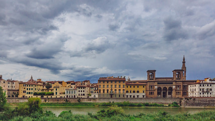 Fototapeta na wymiar Houses and Florence National Central Library over Arno River in Florence, Italy