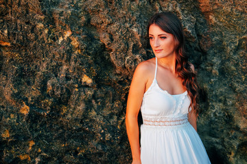 Romantic feminine woman in white dress waiting at the shore