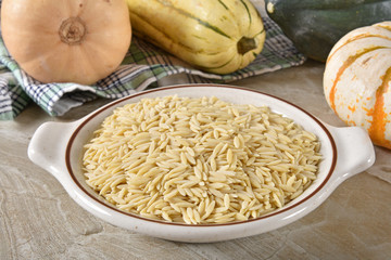 Bowl of raw orzo with ingredients