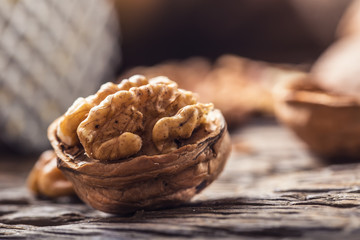 Close-up walnut kernel and whole walnuts on old wooden table