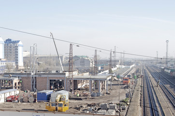 Construction site of the railway station. Truck cranes, workers and construction materials. Retro style. Russia