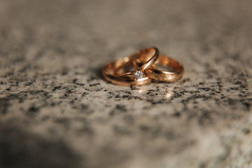 Obraz na płótnie Canvas Wedding rings on table. Gold rings with diamond on sun. Wedding accsessories. macro