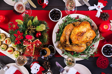 Baked turkey. Christmas dinner. The Christmas table is served with a turkey, decorated with bright tinsel and candles. Fried chicken, table.  Family dinner. Top view