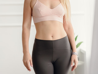 Closeup of fit woman in sportswear showing her slim belly