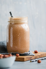Nut butter chocolate protein shake in a glass jar. The concept of a healthy lifestyle and fitness...