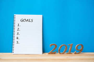 2019 Happy New years with notebook “ Goals “ text and wooden number on table and copy space. New Start, Resolution, Goals and Mission Concept