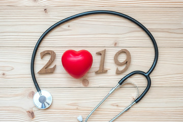 2019 Happy New Year for healthcare, Wellness and medical concept. Stethoscope with red heart and wooden number on table background