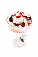Bowl of sweet ice cream decorated with chocolate cookies and syrup isolated at white background.