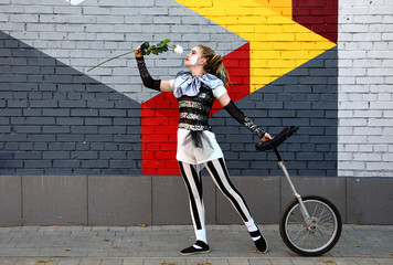 Girl clown with white rose and a unicycle © Alexey Kuznetsov
