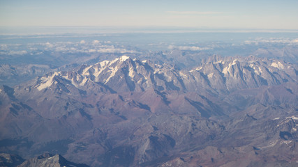 Flying over the European Alps during fall season. Landscape at the Mont Blanc and the glaciers. Aerial view from the airplane window