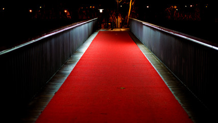 Puente a la noche, iluminado y cubierto con una alfombra roja