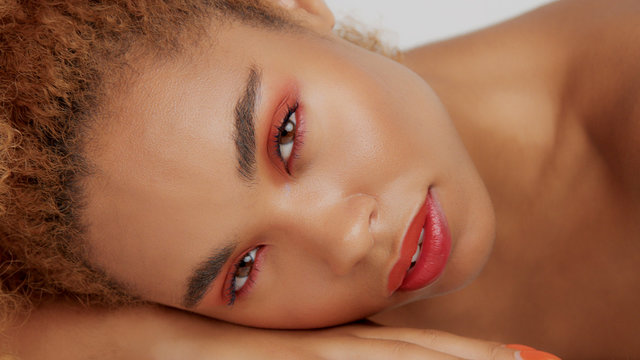 closeup mixed race black woman with red makeup lying down on her own hand