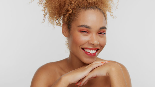 closeup portrait of mixed rase woman with red makeup in studiowatching at camera and smiling