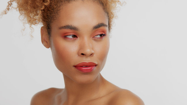 closeup portrait of mixed rase woman with red makeup in studio serious wathing aside
