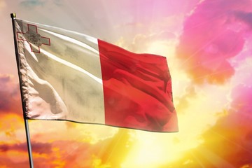 Fluttering Malta flag on beautiful colorful sunset or sunrise background. Success concept.