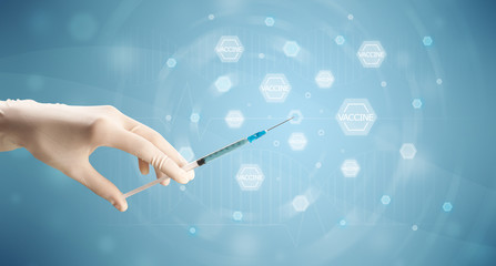 Female doctor hand holding syringe with blue background 