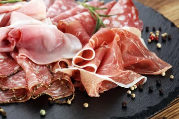 Cercles muraux Viande Planche à découper en marbre avec prosciutto, bacon, salami et saucisses sur fond de bois. Plateau de viande