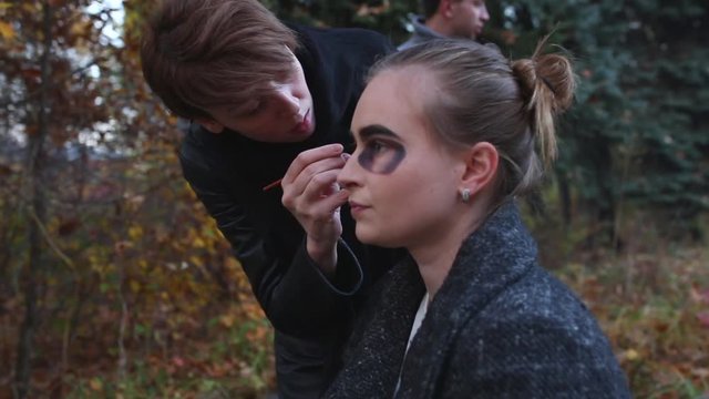 Make-up artist and stylist doing makeup model for Halloween.