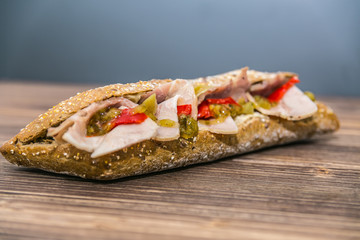 Fresh baguette sandwich on wooden background. Classic BLT sandwiches. Close up.