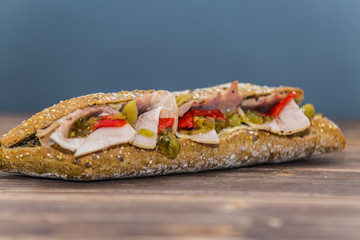 Fresh baguette sandwich on wooden background. Classic BLT sandwiches. Close up.