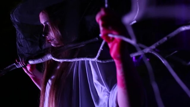 Woman with dead bride make-up for Halloween in the white bride dress in the dark at abandoned house