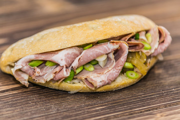 Fresh baguette sandwich on wooden background. Classic BLT sandwiches. Close up.