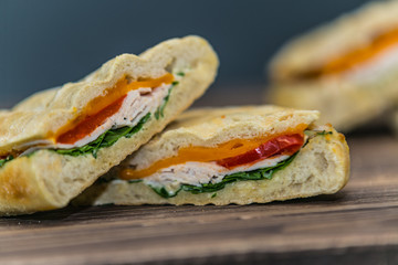 Fresh baguette sandwich on wooden background. Classic BLT sandwiches. Close up.