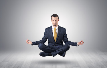 Businessman levitates and sitting in yoga position in an empty infinity space

