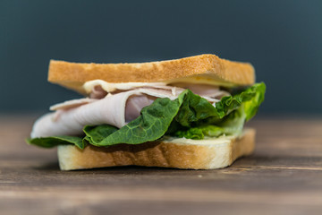 Fresh baguette sandwich on wooden background. Classic BLT sandwiches. Close up.