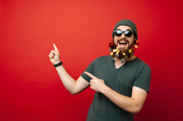 Happy man with decorated christmas beard pointing away