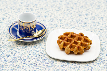 coffee and belgian waffle on flower pattern tablecloth