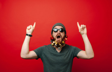 Portrait of excited man with decorated christmas beard pointing up