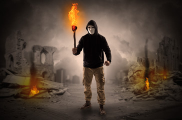 Obraz premium Destroyed place after a catastrophe with man and burning flambeau concept 