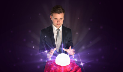 Young businessman sitting with crystal ball in action