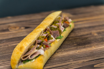 Fresh baguette sandwich on wooden background. Classic BLT sandwiches. Close up.