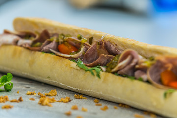 Fresh baguette sandwich on wooden background. Classic BLT sandwiches. Close up.