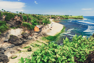 Fototapeta na wymiar Azure beach with rocky mountains and clear water of Indian ocean at sunny day / A view of a cliff in Bali Indonesia / Bali, Indonesia