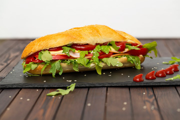 Sandwich with ham, cheese, tomatoes, sauce and salad