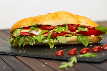 Sandwich with ham, cheese, tomatoes, sauce and salad