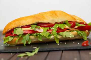 Sandwich with ham, cheese, tomatoes, sauce and salad