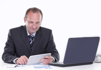 businessman uses a digital tablet while sitting at his Desk