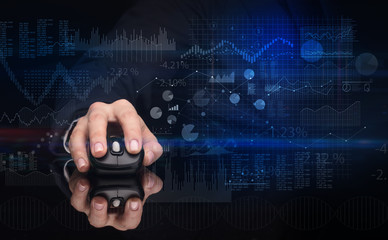 Hand using wireless mouse with financial concept on dark background
