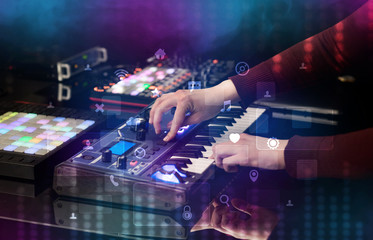 Hand mixing music on dj controller with social media concept icons
