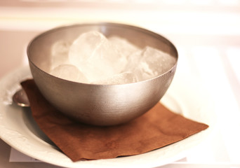 Chunks of ice in a bowl in restaurant in Catania, Sicily, Italy