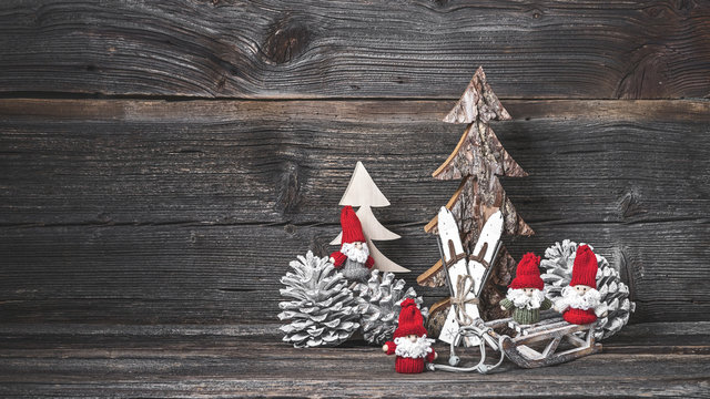 Vier Weihnachtsm&auml;nner vor rustikalem Holz