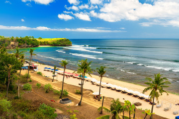Azure beach with rocky mountains and clear water of Indian ocean at sunny day / Balangan Beach in Bali Indonesia 