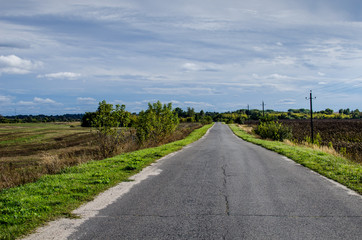 Fototapeta na wymiar The road stretches into the distance. Asphalt Road between villages in Russia