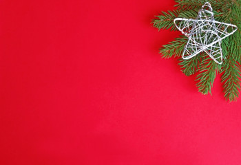 red and green christmas background with a silver star on spruce