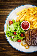 Grilled steak, French fries and vegetables