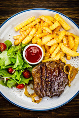 Grilled steak, French fries and vegetables